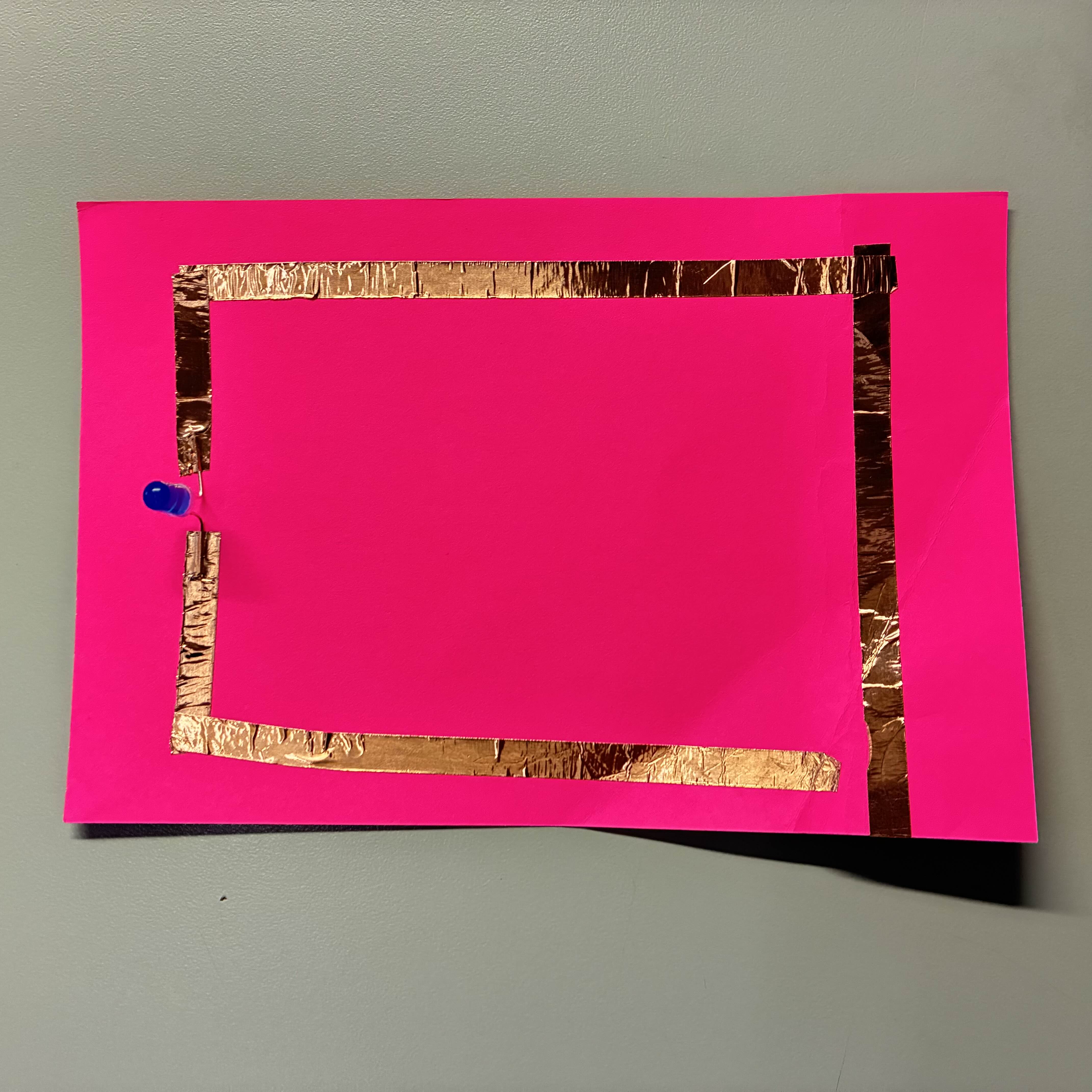 This was my simple circuit, I used pink paper as my base and a blue light to contrast the pink. I had a lot of trouble lining up the fold so that the each end of the copper tape would touch the battery.