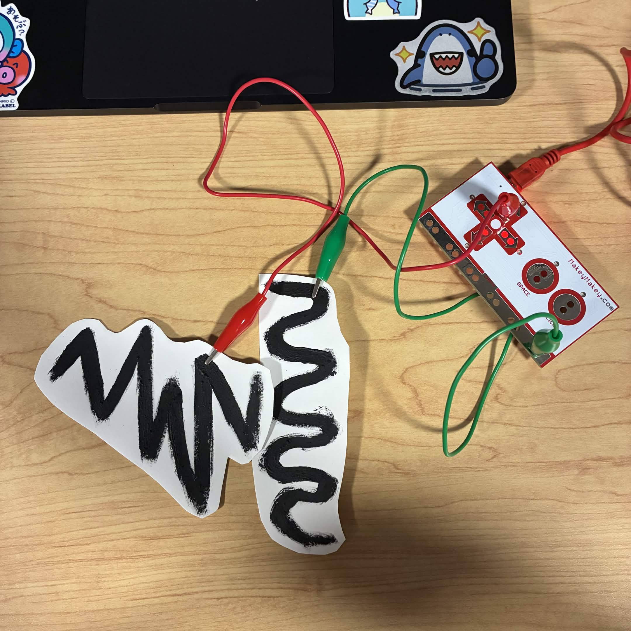 I cut out the lines I made out of conductive paint and connected it to the Makey Makey. The green wire is connected to the ground and the red wire is connected to the up button.