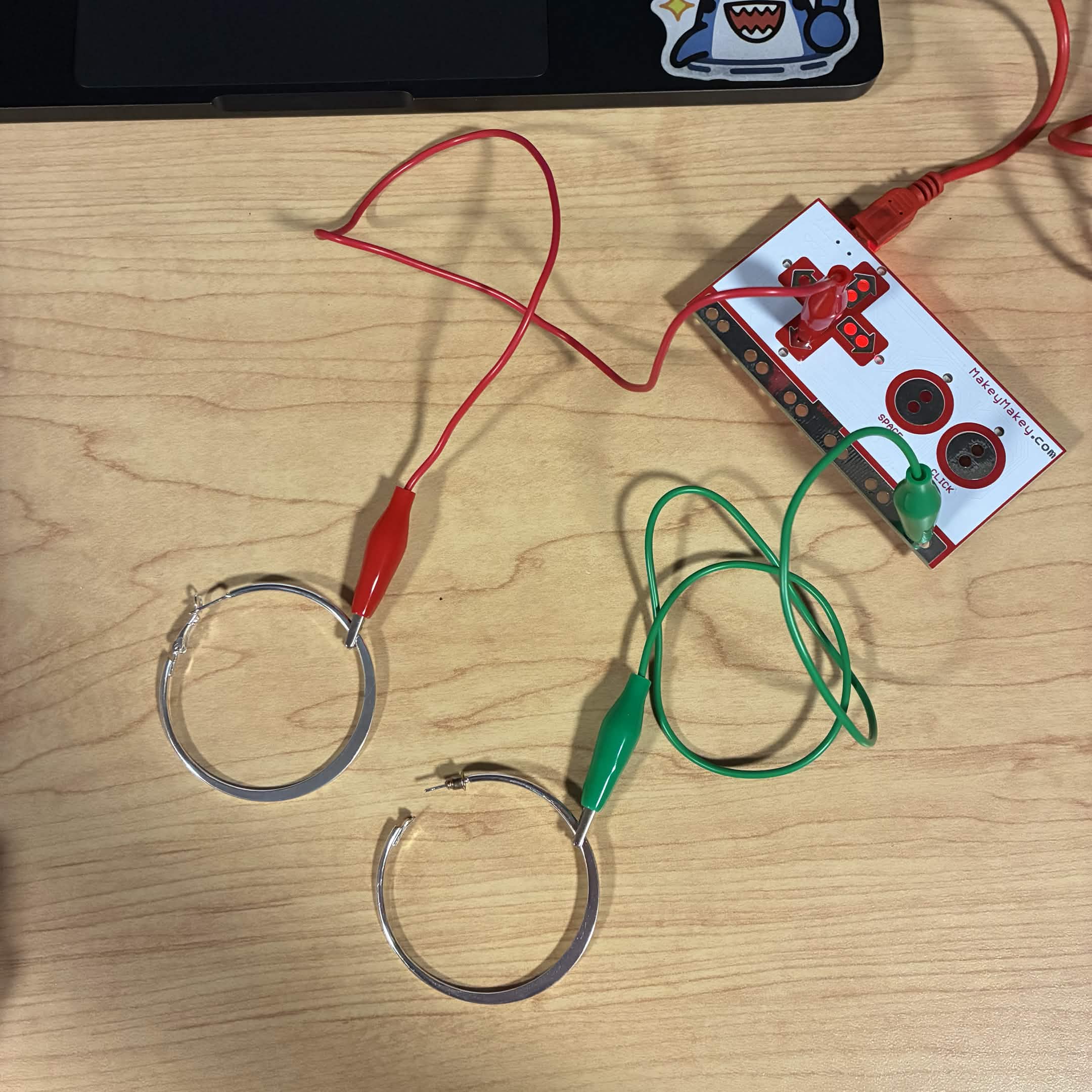 I wanted to try a more unconventional item so I connected my silver hoop earrings to the Makey Makey. The green wire is connected to the ground and the red wire is connected to the down button.