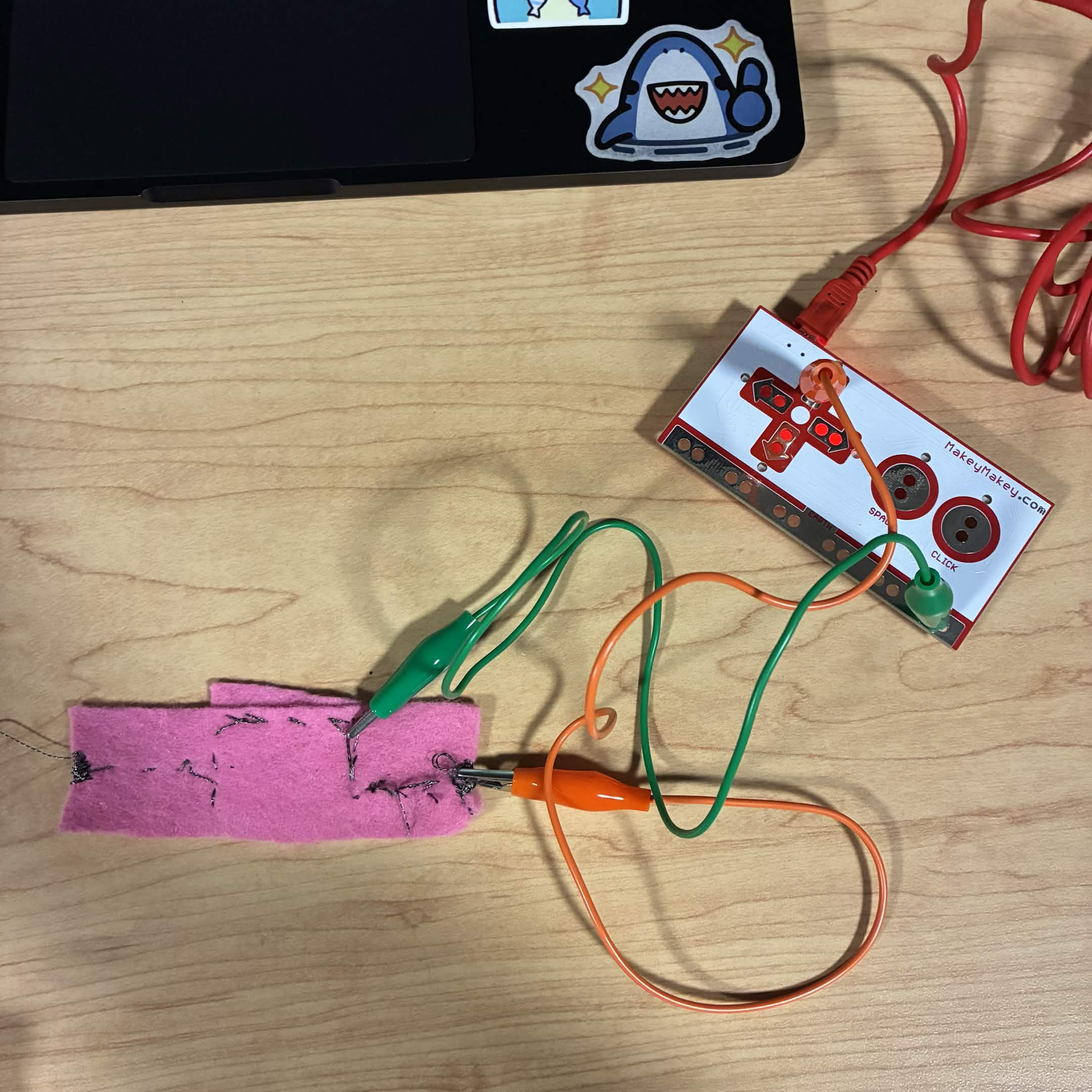 I found the conductive thread that was stitched into felt from module 1. I connected my alligator clip wires to it to see if it would work. The green wire is connected to ground and the orange wire is connected to the up button.